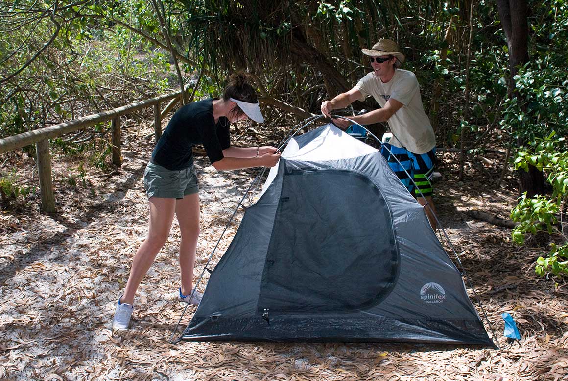 A young couple setting up a tent on Whitsunday Islands National Park